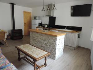 cocina con encimera de piedra, mesa y banco en Les Lavandes d'Estoublon en Estoublon
