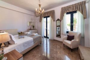 a bedroom with a bed and a chair and a mirror at Kallisti in Panormos Rethymno