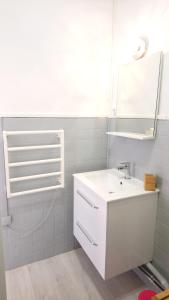 a white bathroom with a sink and a mirror at Studio cosy proche Gare in Libourne