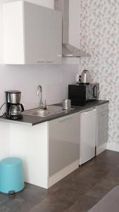 a kitchen with a sink and a microwave at Studio cosy proche Gare in Libourne
