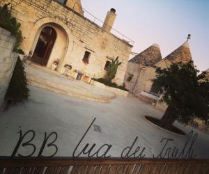 un edificio con un cartello che dice bc abbiamo avuto fede di B&B Via dei Trulli a Cisternino