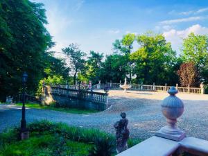 a statue in a garden with a fence and trees at Charme of Villa Capannina in Novi Ligure +34 photos