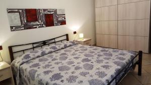 sypialnia z łóżkiem z narzutą kwiatową w obiekcie Casa Vacanza Sardegna w mieście Valledoria