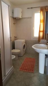 e bagno con servizi igienici, lavandino e doccia. di Casa Vacanza Sardegna a Valledoria