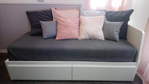 a bed with several pillows on top of it at Studio cosy proche Gare in Libourne