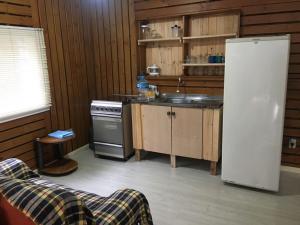 a kitchen with a white refrigerator and a sink at Apartamento Terreo em Caxias do Sul in Caxias do Sul