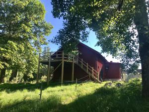 une grange rouge assise au sommet d'une pelouse dans l'établissement Björnåsen Bear Hill, à Katrineholm