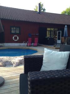 カトリーネホルムにあるBjörnåsen Bear Hillの家の前にソファと椅子が備わるプールがあります。