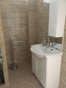 a bathroom with a white sink and a shower at Kovács apartman in Balatonberény +28 photos