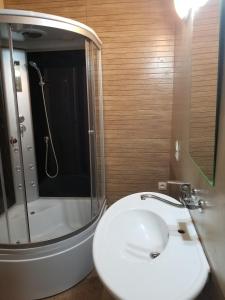 ein Badezimmer mit einem weißen Waschbecken und einer Dusche in der Unterkunft Apartment Irma Rustaveli 57 in Batumi