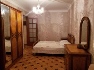 um quarto com uma cama e um lustre em Apartment Irma Rustaveli 57 em Batumi
