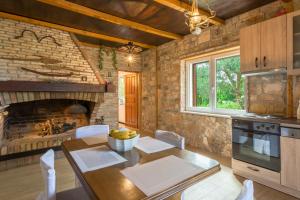 eine Küche und ein Esszimmer mit einem Tisch und einem Kamin in der Unterkunft Casa Mala in Zadar