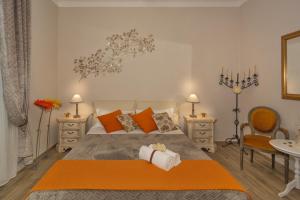 ein Schlafzimmer mit einem großen Bett mit orangefarbenen Kissen in der Unterkunft A due passi dalla torre in Pisa
