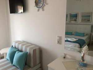 Dormitorio pequeño con cama y espejo en Spyridonou House, en Parga