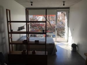 1 dormitorio con 1 cama y una gran ventana de cristal en Depto en Belgrano 3 de febrero en Buenos Aires