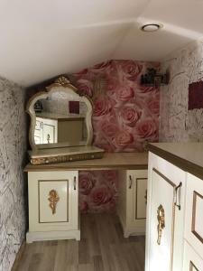 a bathroom with a mirror and roses on the wall at Plata iela Ventspils center apartment in Ventspils