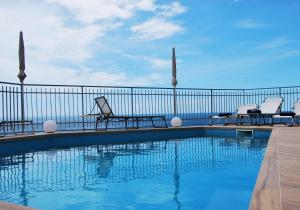 uma piscina com cadeiras e uma cerca em Villa Elizabeth em Conca dei Marini