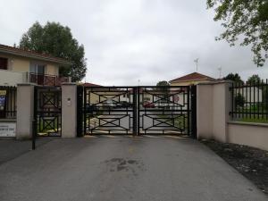 ein offenes Tor zu einem Haus mit Auffahrt in der Unterkunft Les jardins de Theo in Hasnon