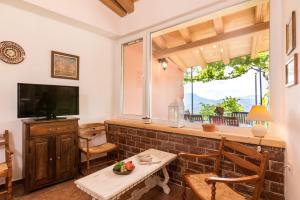 a living room with a table and a television at Milena's Country House in Pelekas