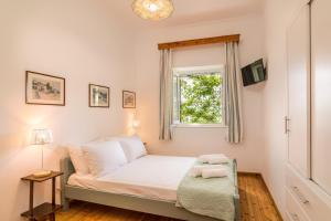 a small bedroom with a bed and a window at Milena's Country House in Pelekas