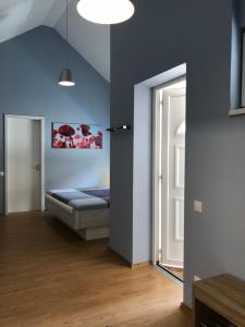 a bedroom with blue walls and a bed and a window at White Crow House in Hévíz