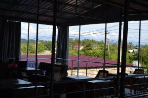 een kamer met tafels en stoelen en uitzicht op een tennisbaan bij Saba Guest House in Ureki
