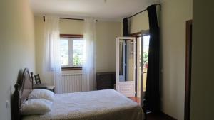 a bedroom with a bed and a window and a door at Casa das Oliveiras in Beiral do Lima