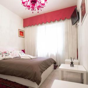 a bedroom with a bed and a red wall at Asher's House Colosseum in Rome