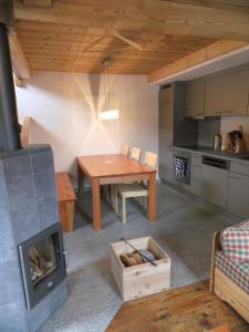 eine Küche und ein Wohnzimmer mit einem Tisch und einem Kamin in der Unterkunft Mybruson in Bruson