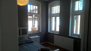 ein Schlafzimmer mit Fenstern, einem Bett und einer Lampe in der Unterkunft Quartier im Burghof in Flensburg