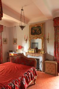 - une chambre avec un lit, une cheminée et un miroir dans l'établissement Chateau de Saint Martin, à Taradeau