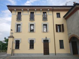 żółty budynek z oknami i drzwiami w obiekcie B&B Molinetto w mieście Piacenza