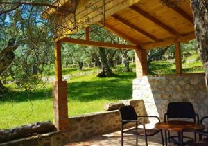 un patio con sillas y una mesa bajo un techo de madera. en Olive Paradise en Ulcinj