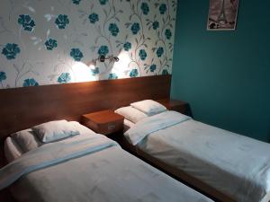 two twin beds in a room with a wall at Bed & Breakfast Green Roof in Rybarzowice