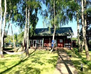 a red house with trees in front of it at Senelio Romo Sodyba in Molėtai