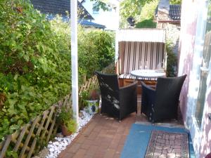 a small garden with a table and chairs on a patio at Bungalow Toscana - 350m zum Strand in Ostseebad Koserow