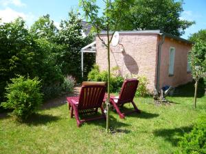 two chairs and a table in a yard at Bungalow Toscana - 350m zum Strand in Ostseebad Koserow