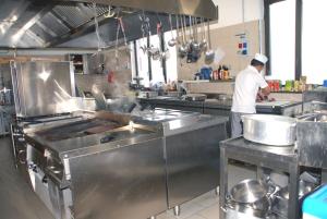 a man standing in a kitchen preparing food at Hotel Ristorante Il Calipso by Mago in Robecchetto con Induno