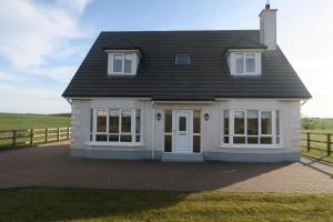 巴利纳THISTLEDOWN - Ballina - Crossmolina - County Mayo - Sleeps 8 - Sister property to Inglewood的一栋带有黑色屋顶的白色房子