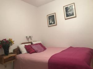 a bedroom with a bed with purple sheets at Guest House Villa Alea in Dobra Voda