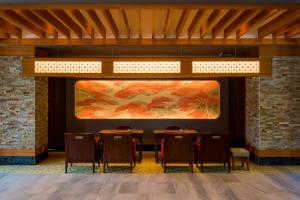 ein Esszimmer mit Stühlen und einem Gemälde an der Wand in der Unterkunft Unzen Kyushu Hotel in Unzen
