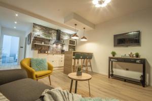 a living room with a couch and a tv and a kitchen at Apartment Green in Zadar