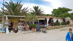 a restaurant on the beach with people sitting at tables at Apartment Tonci in Novalja