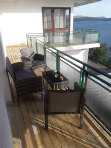 a balcony with two chairs and a glass railing at Dalmatino in Brodarica