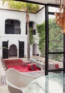 uma sala de estar com uma mesa de vidro e vista para um pátio em P´tit Habibi em Marrakech