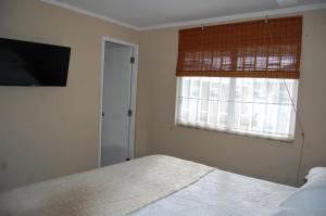 a bedroom with a bed and a television and a window at Tronador I in Puerto Montt
