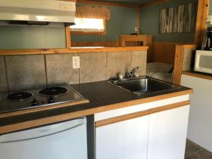 a kitchen with a sink and a stove at Piccadilly Motel in Radium Hot Springs