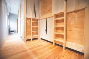 a room with wooden walls and wooden floors at Noboribetsu Guest House AKA & AO in Noboribetsu