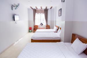 a bedroom with two beds and a window at Hoang Thinh Hotel in Kon Tum (2)