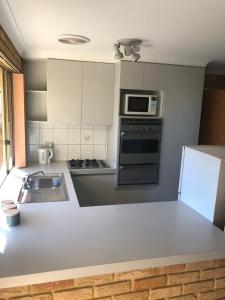 a kitchen with a white counter top and a microwave at Dampier House Mullaloo-Perth in Perth